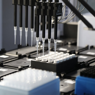 An automated liquid-handling robot dispensing samples into tubes