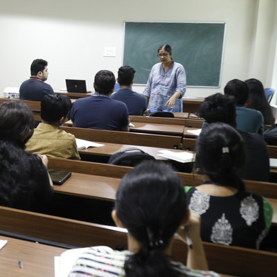 A faculty member teaching students in a lecture hall during an outreach session